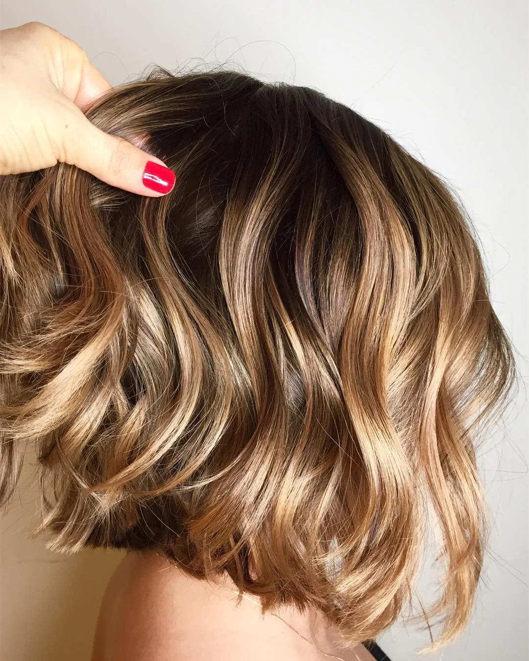 modern summer haircut 2026 Caramel Wavy Bob With Bright Ribbon Highlights
