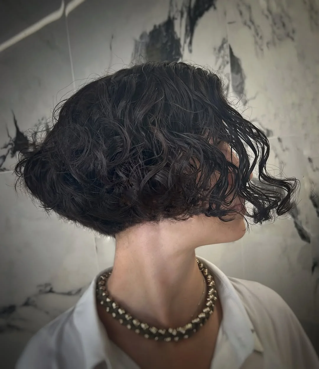modern summer haircut 2026 Wet-Look Curly Bob With Sculpted Volume