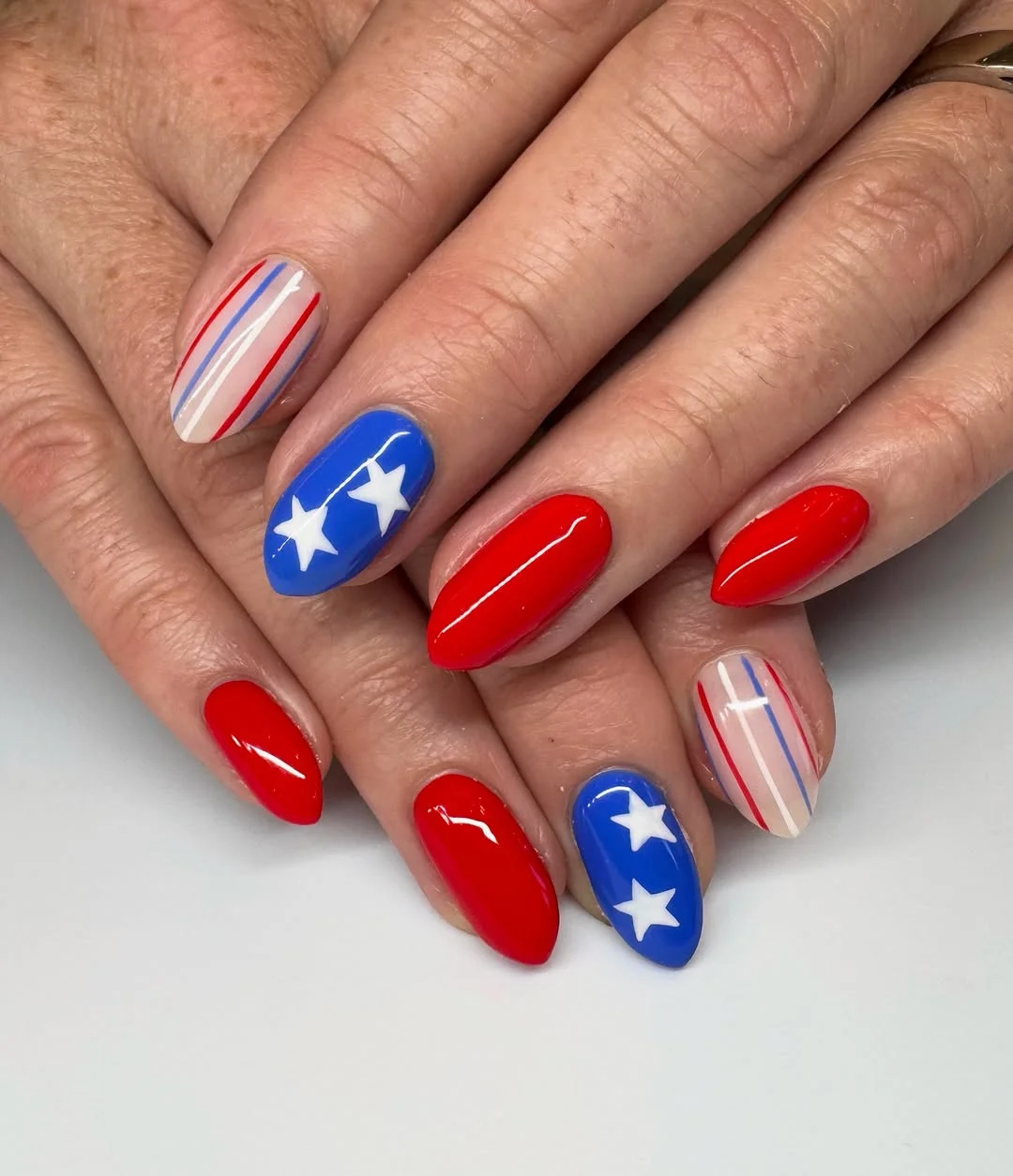 patriotic nails 2026 + Glossy Red Almond Nails with Bold Blue Star Accents