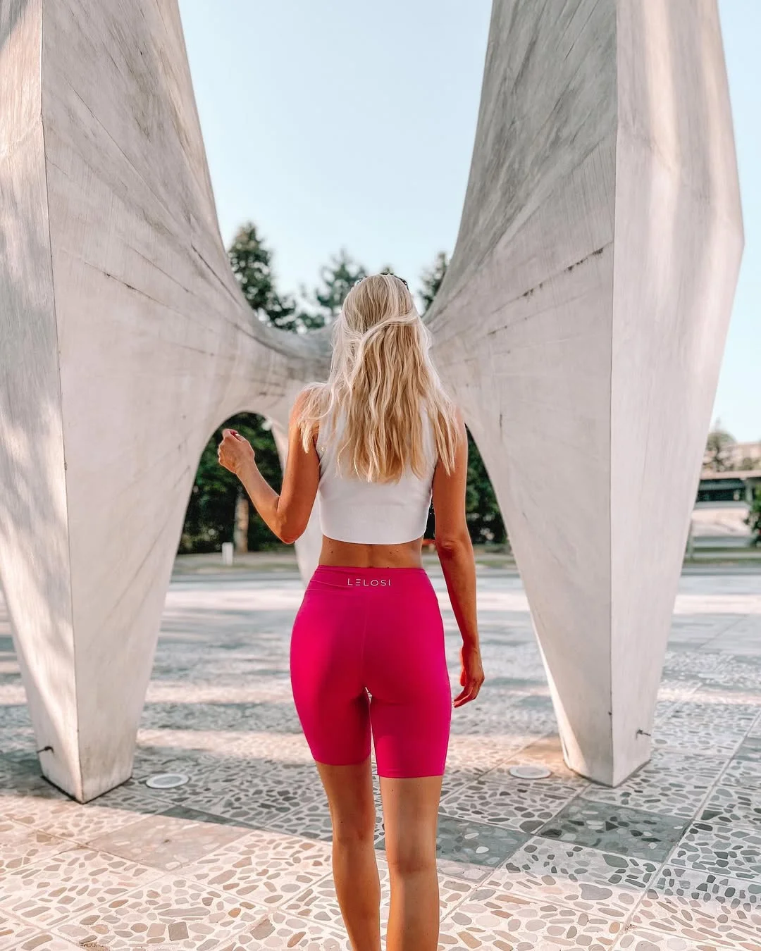 sporty legging outfits summer 2026 Hot Pink Biker Shorts With A Minimal White Crop Top