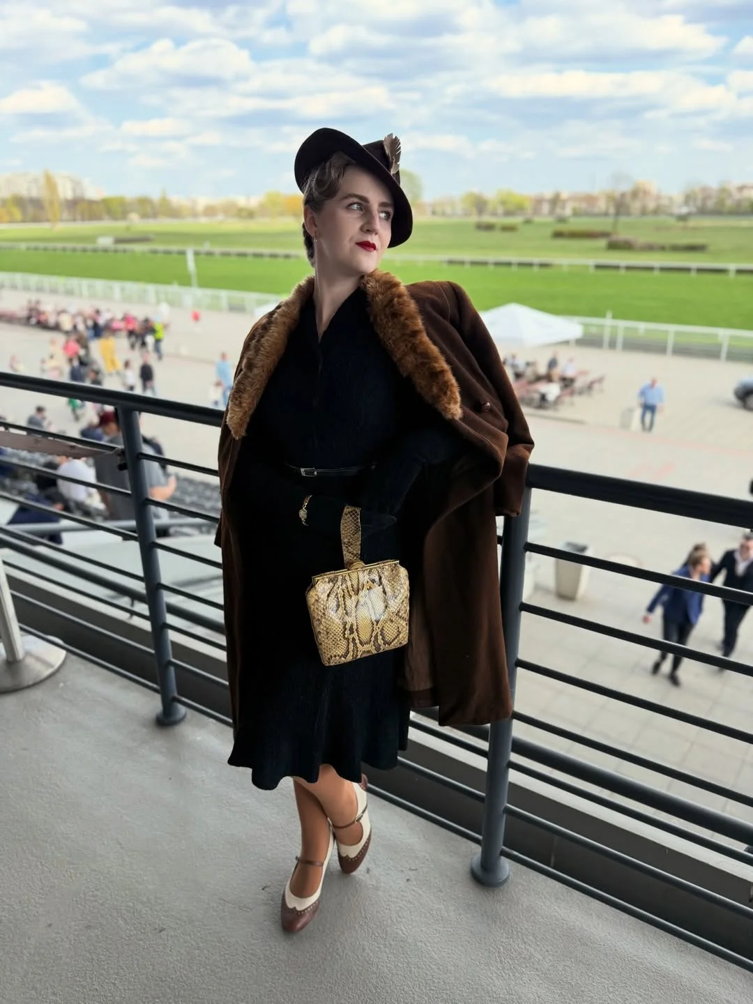 fall outfits for women in 30s style 2026 - A Black Midi Dress and Brown Coat for a Refined Outdoor Event