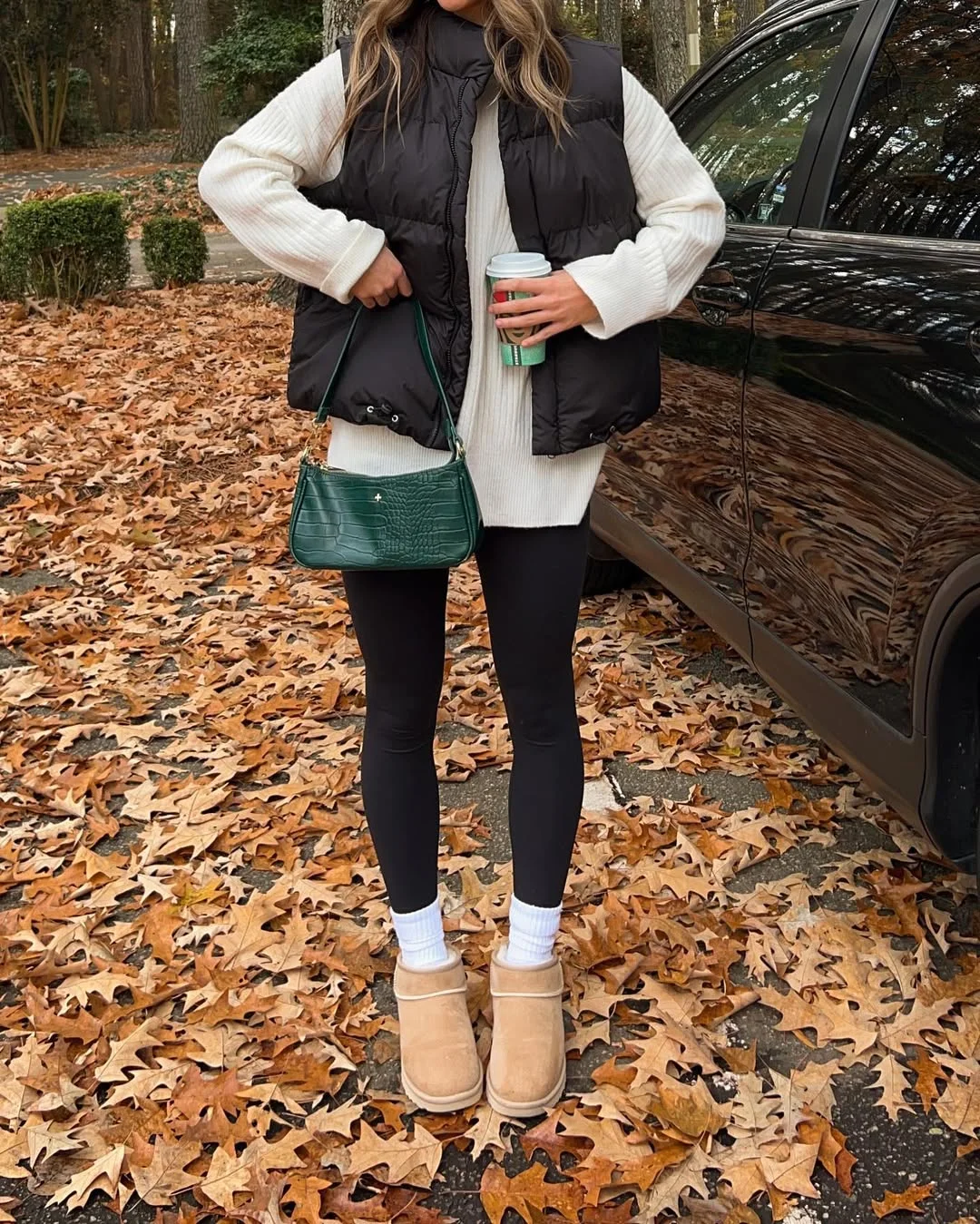 fall outfits with leggings and boots 2026 + Black Puffer Vest With Mini Boots and a Pop of Green