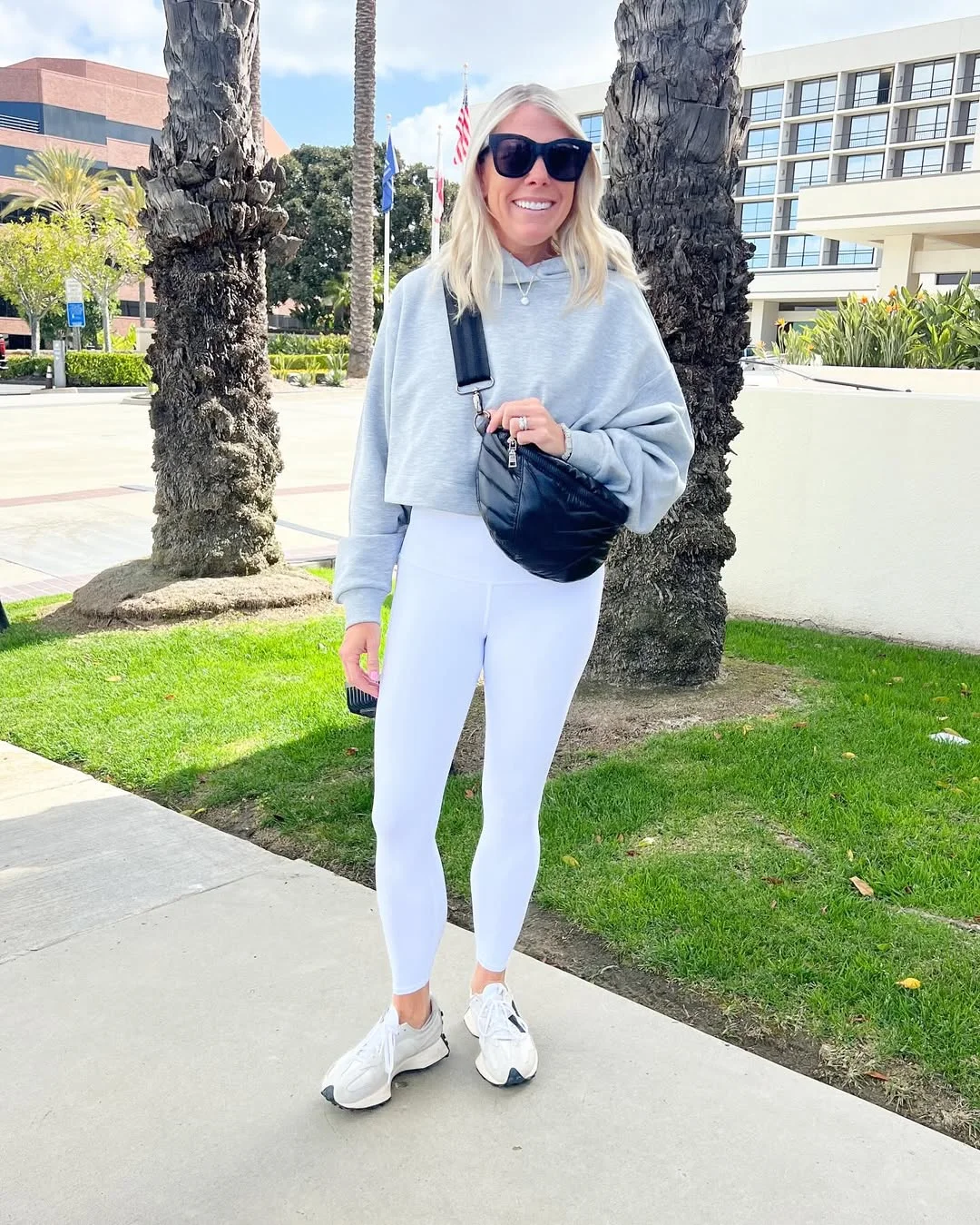 fall outfits with leggings and sneakers 2026 Gray Cropped Hoodie With White Leggings And A Black Sling Bag