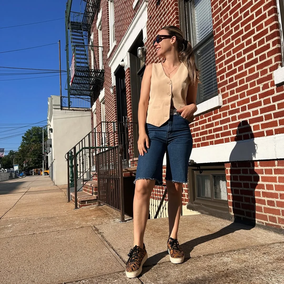 fall vest outfits for women 2026 Tan Vest and Denim Bermuda Shorts for Warm Fall Days