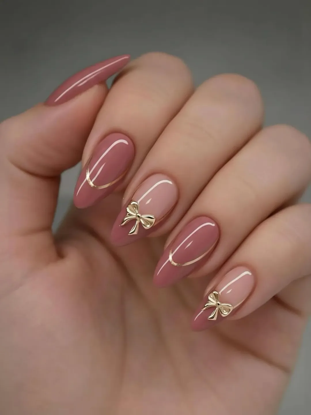 july nails design ideas 2026 + Mauve Almond Nails With Gold Bow Details