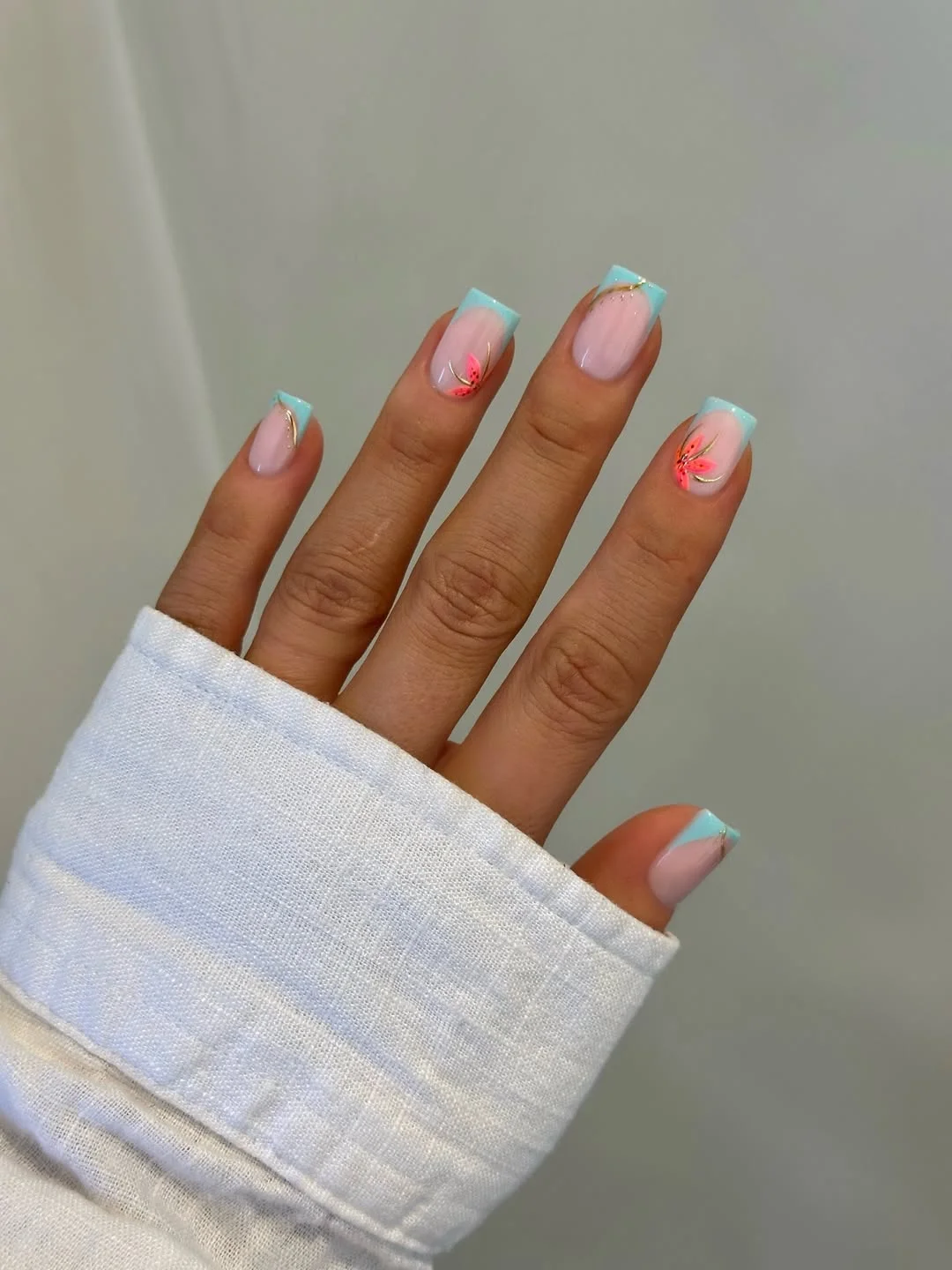 july nails design ideas 2026 + Aqua French Tips With Coral Floral Accents