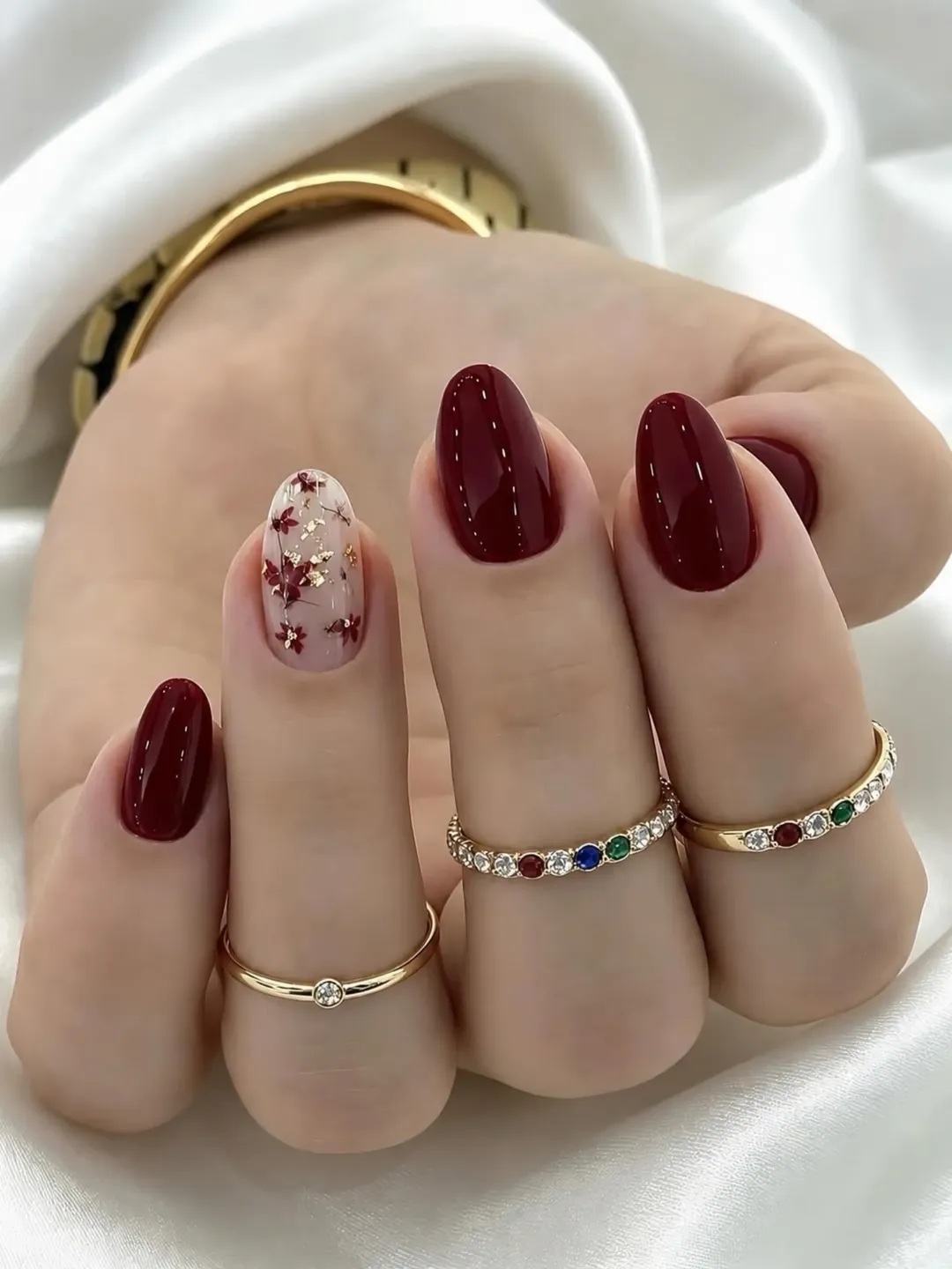 july nails design ideas 2026 + Glossy Burgundy Nails With a Floral Gold Accent