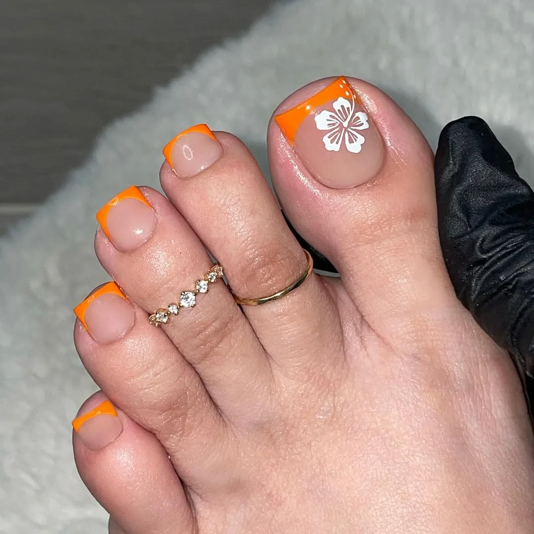 July toe nail colours ideas 2026 Orange French Tips With A White Hibiscus Accent