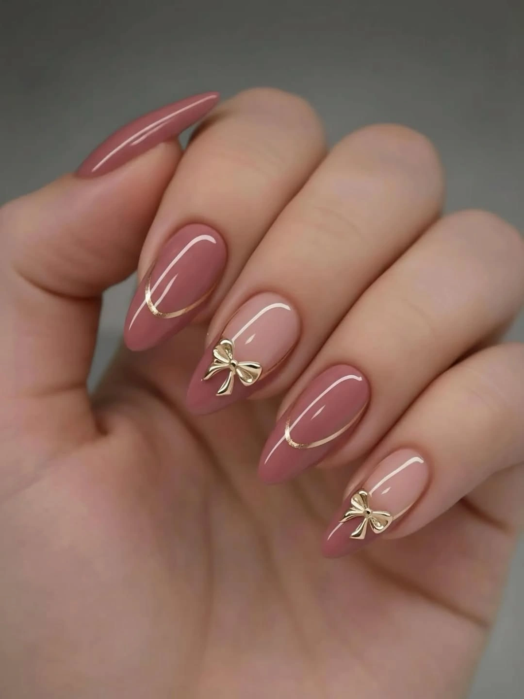 august nails ideas 2026 + Dusty Rose Almond Nails With Gold Bow Details