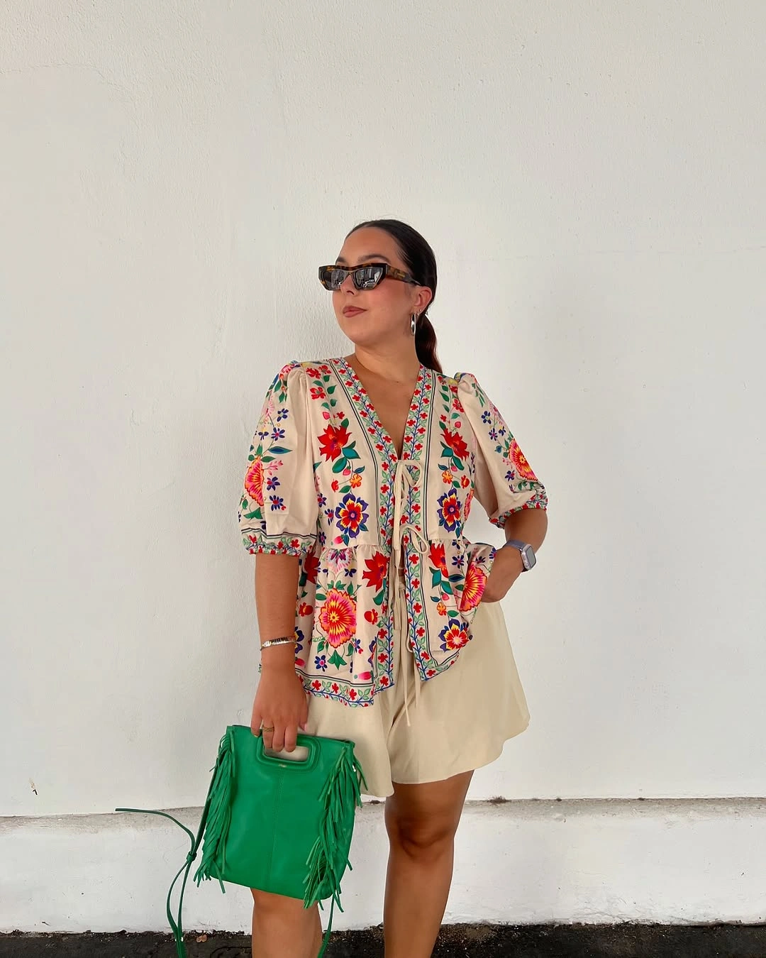 august outfits 2026 + Floral Blouse and Cream Shorts With a Bright Green Bag