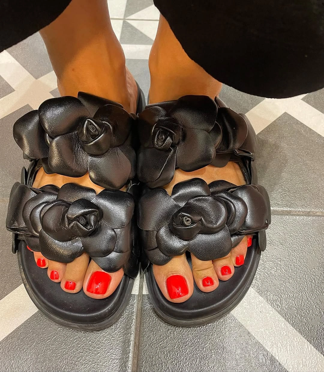 august pedicure nails ideas 2026 + Cherry Red With Statement Black Flower Slides