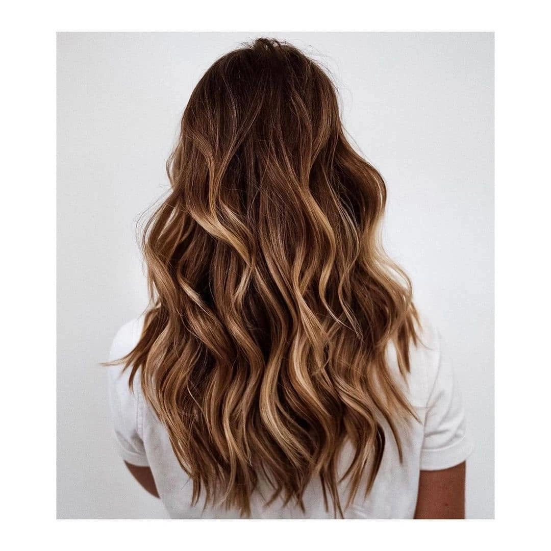 body waves hairstyle Warm Brunette Waves Lit With Caramel Ribbons