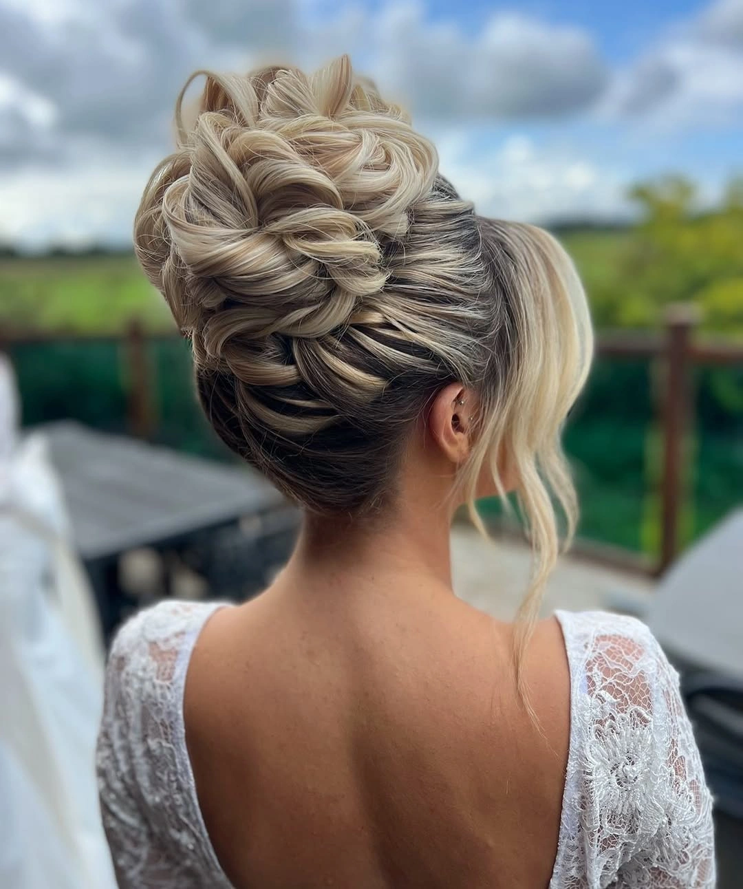 bridesmaid hairstyling Sculpted High Updo With Woven Blonde Loops
