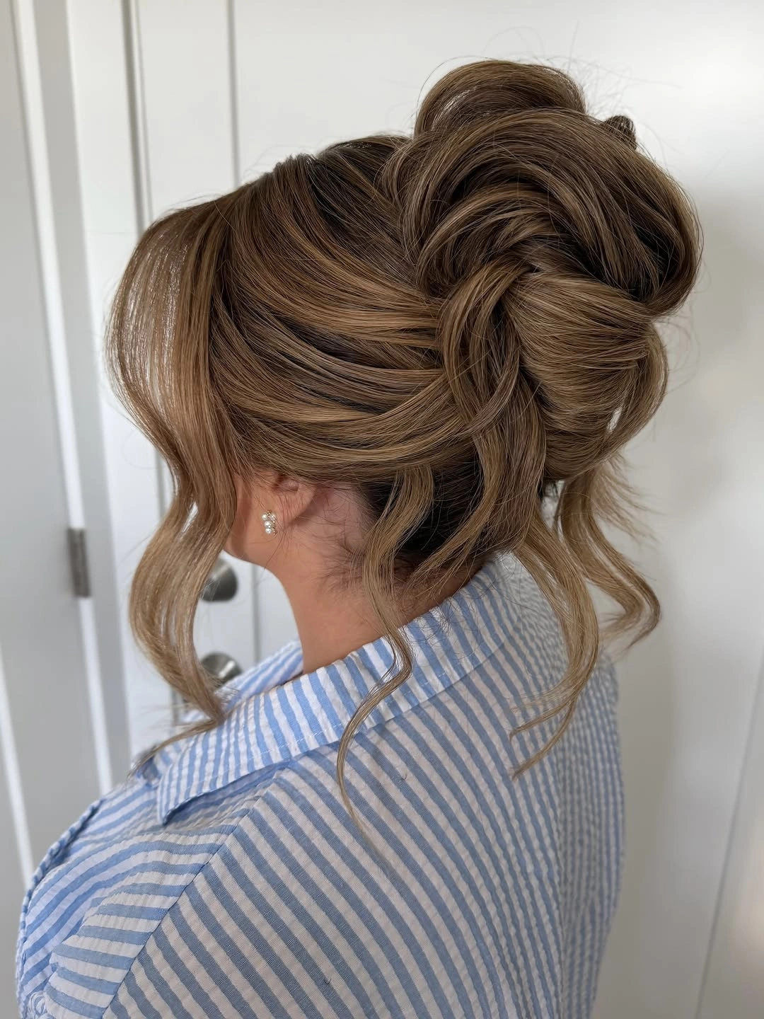 bridesmaid hairstyling Voluminous High Bun With Airy Bangs