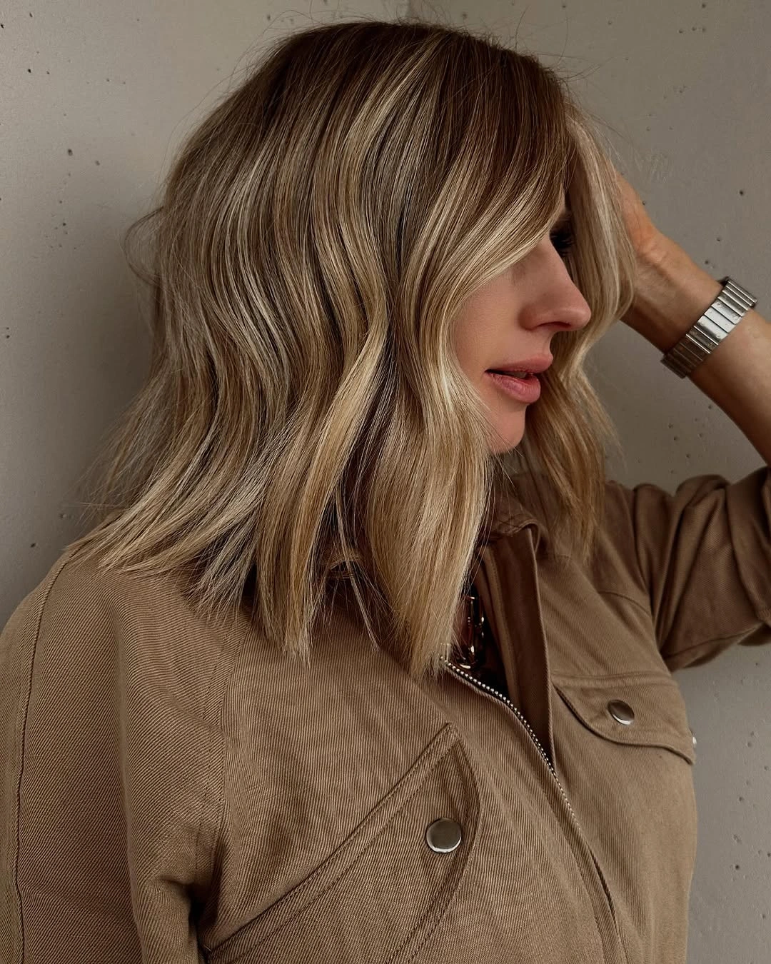 dirty blonde hair color Smoky Bronde Waves With A Camel Jacket