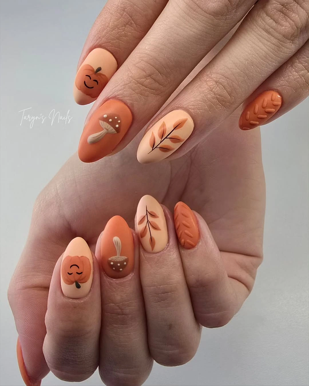 fall almond nails 2026 Pumpkin Orange Almond Nails With Leaf Motifs