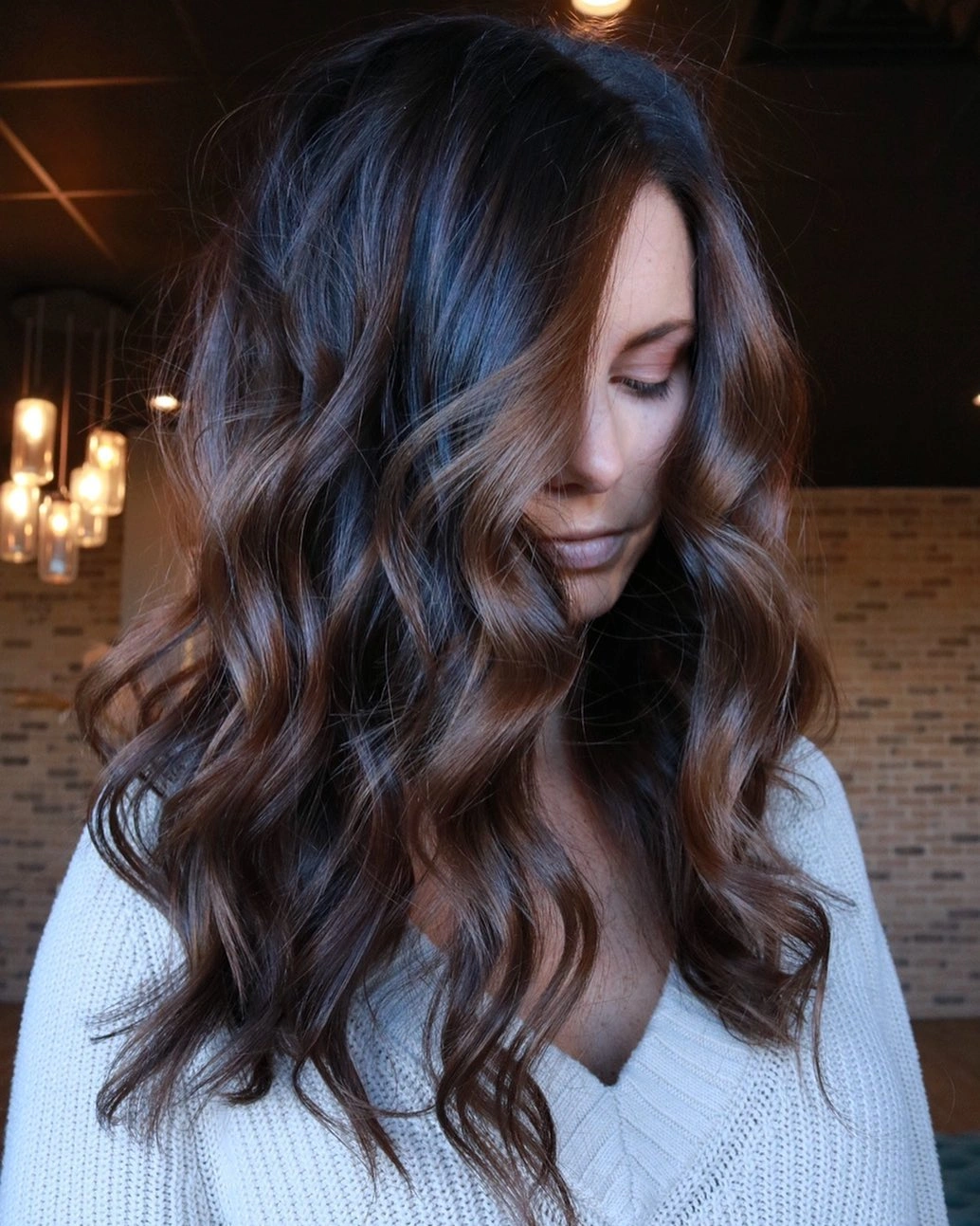 Fall brunette hair colour 2026 Chestnut Waves Framed by Soft Ivory Knitwear