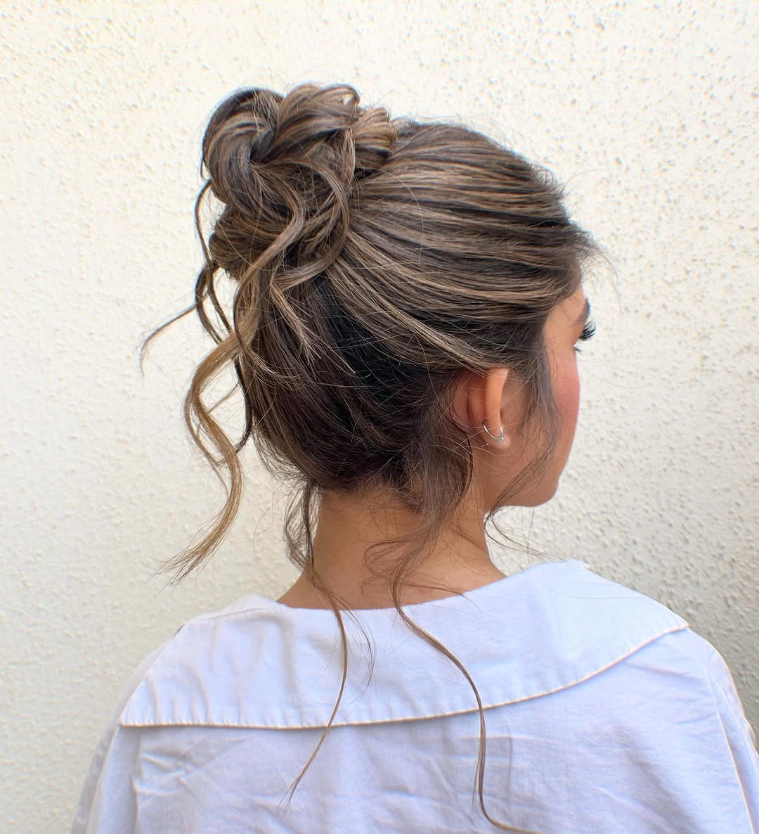 fall hairstyles 2026 Relaxed Highlighted Bun With Loose Tendrils