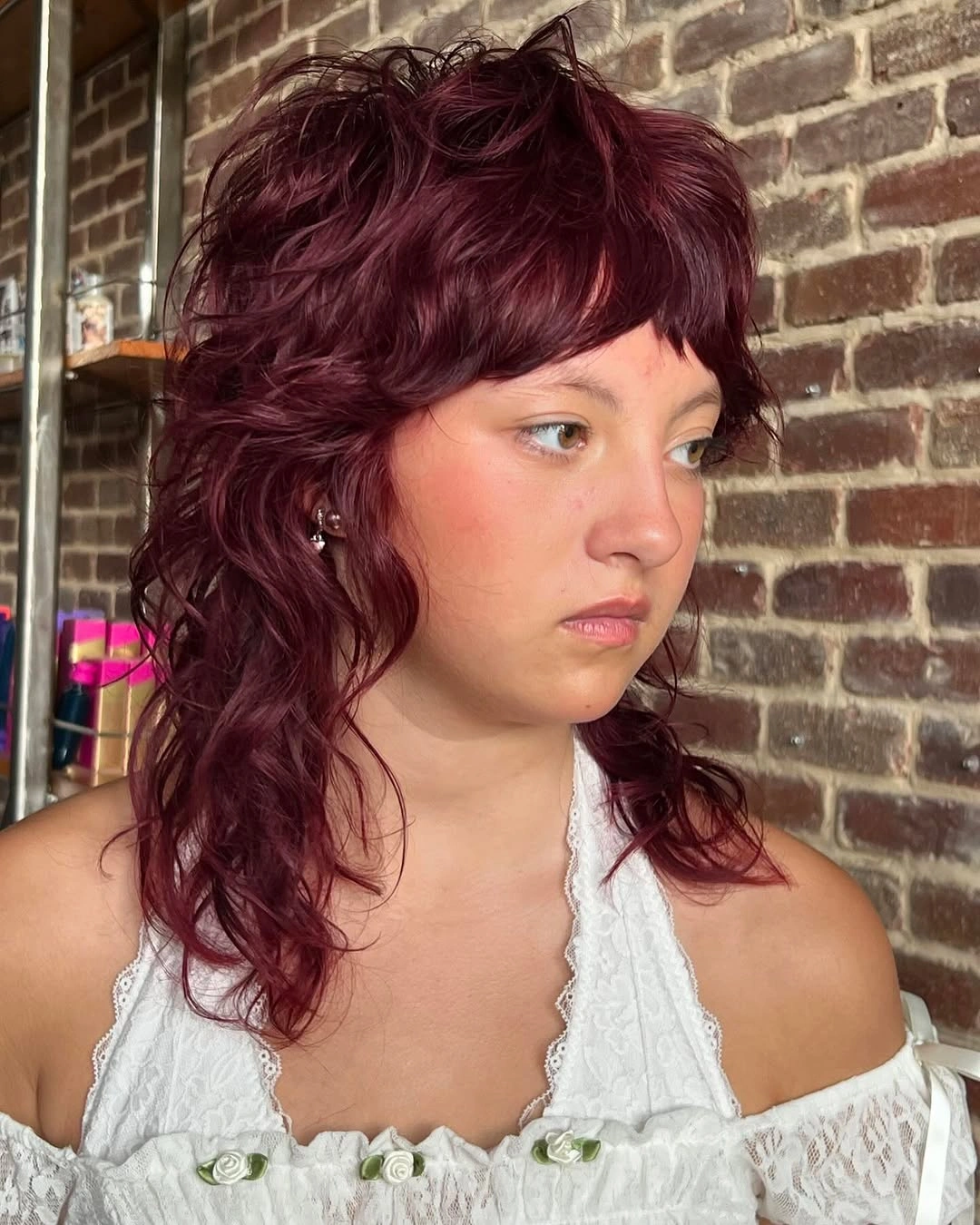 fall hairstyles 2026 Burgundy Curly Shag With Soft Baby Bangs