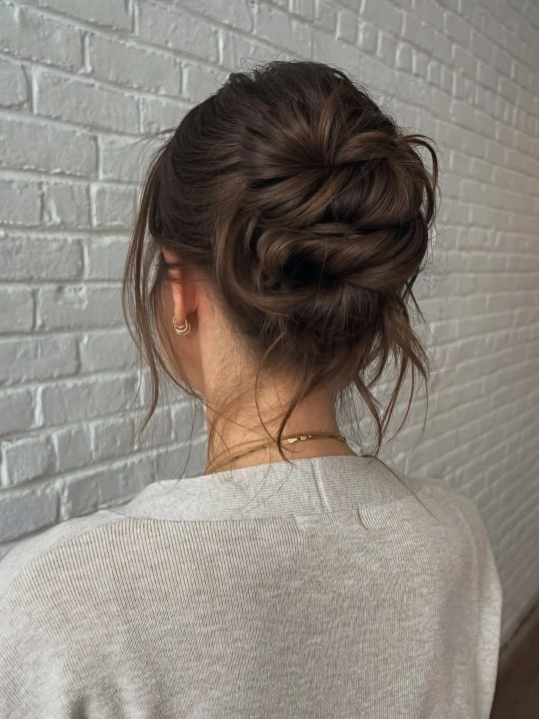 fall hairstyles for wedding guests 2026 Textured Brunette Bun With Cozy Fall Softness