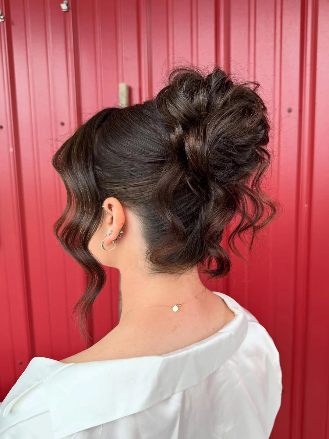 fall hairstyles for wedding guests 2026 Dark Curly High Bun With A Crisp White Collar