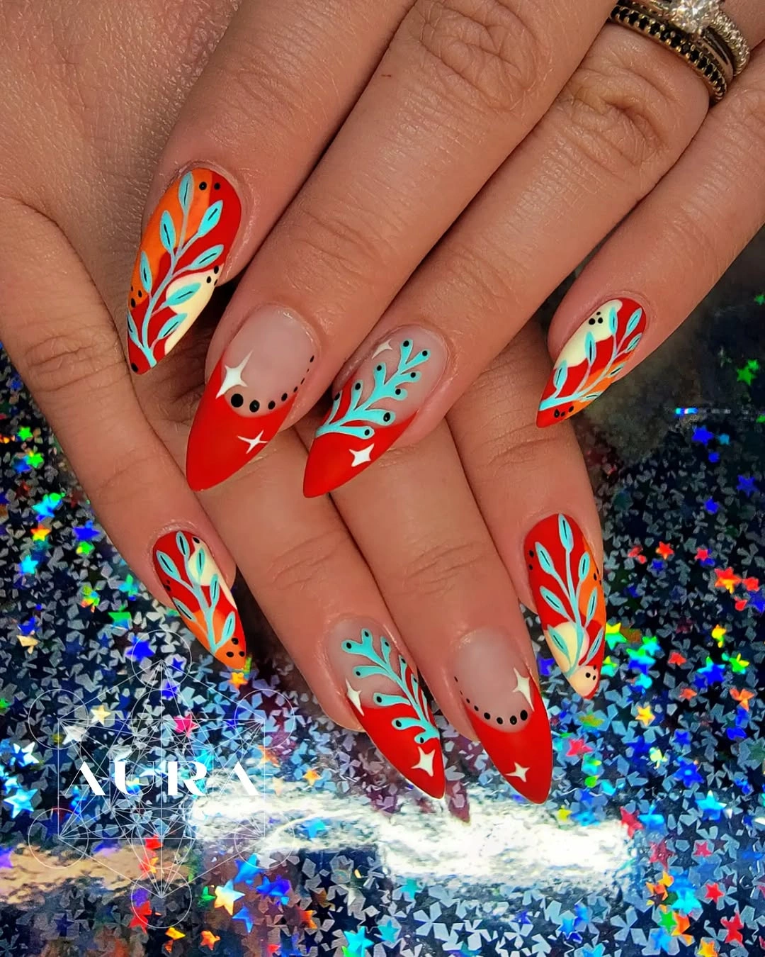september nail designs 2026 Orange Nails with Teal Leaf Graphics