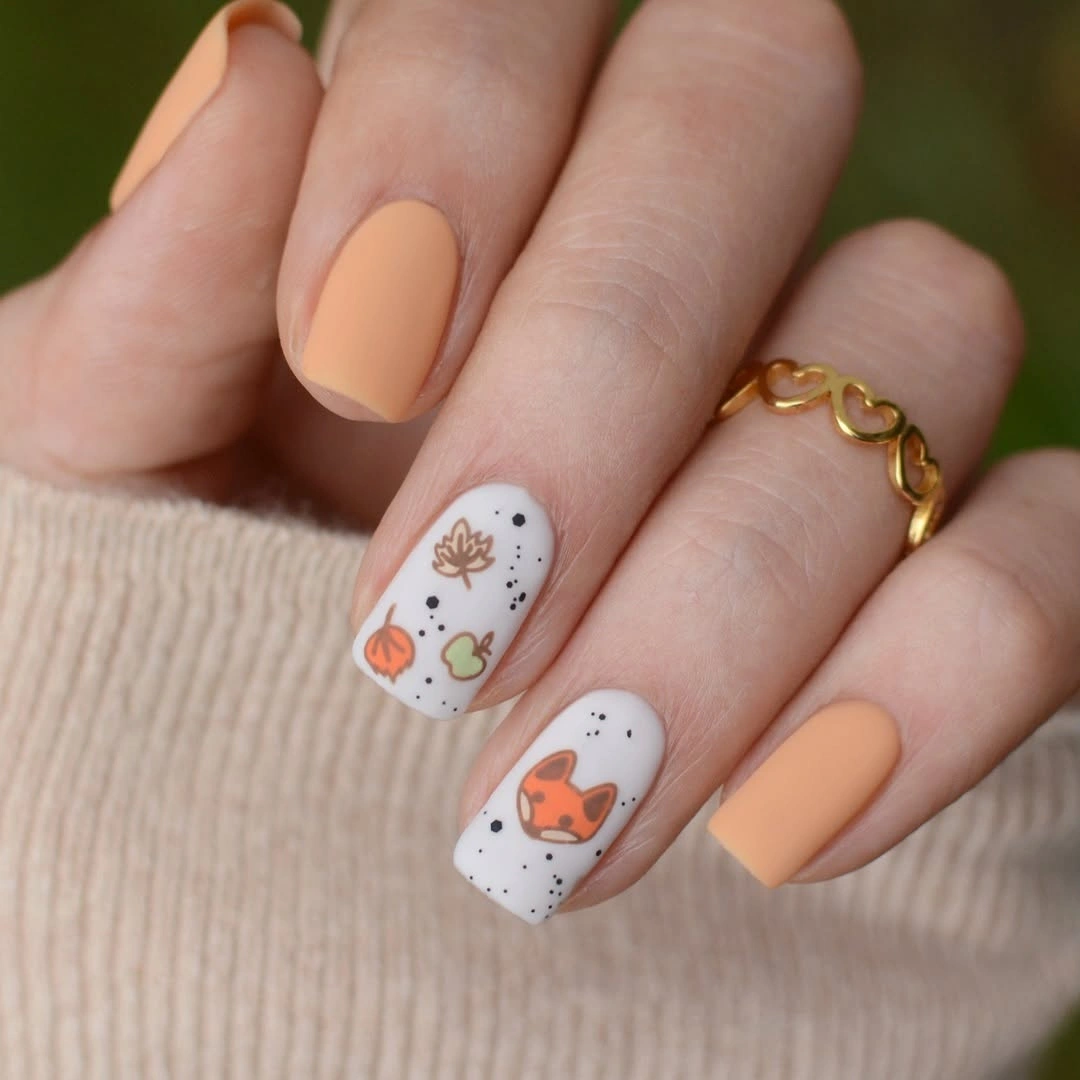 Short peach matte nails with white seasonal accent details