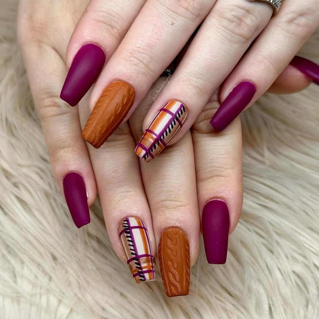 Long burgundy square nails with orange texture and stripe accents