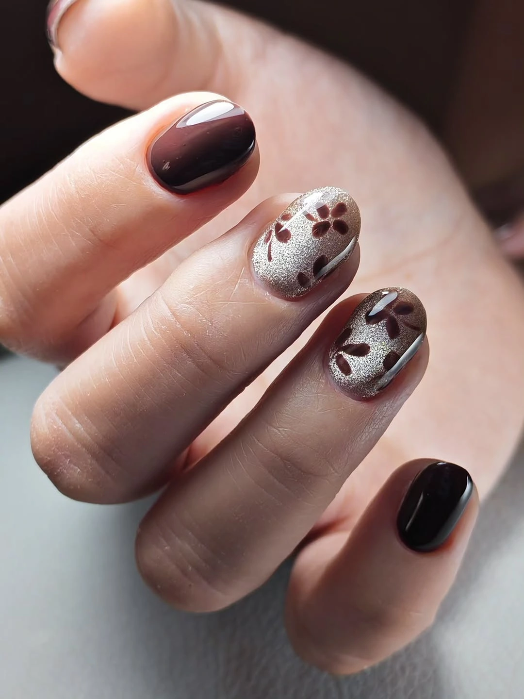 Short brown glossy nails with pale shimmer accent details