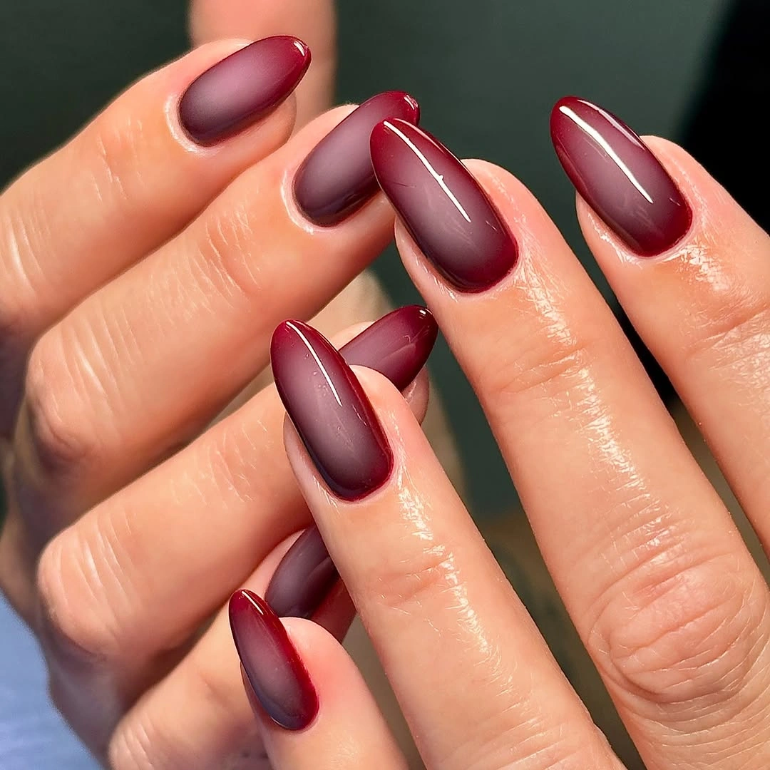Medium-long burgundy almond nails with a glossy tonal gradient