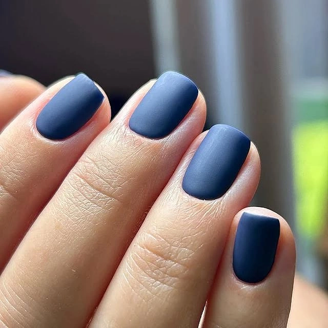 Short square nails in a deep navy matte shade