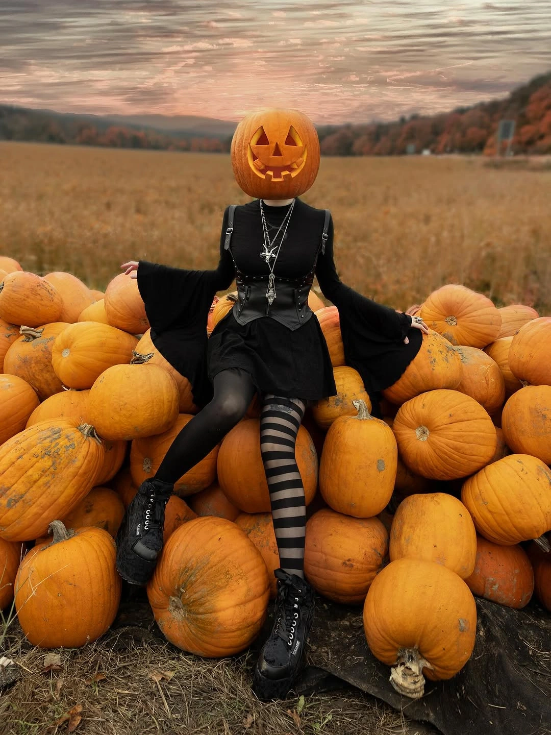 black outfit with wide sleeves, short dark skirt, striped tights, and heavy boots