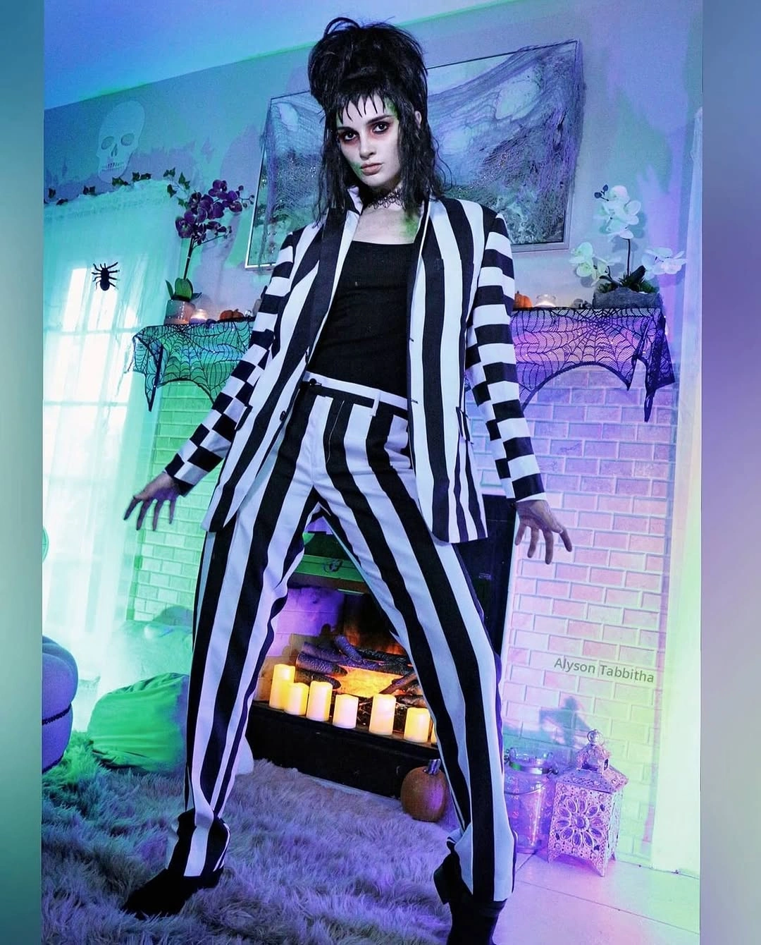 black outfit with tailored blazer over wide-leg trousers with a long vertical line
