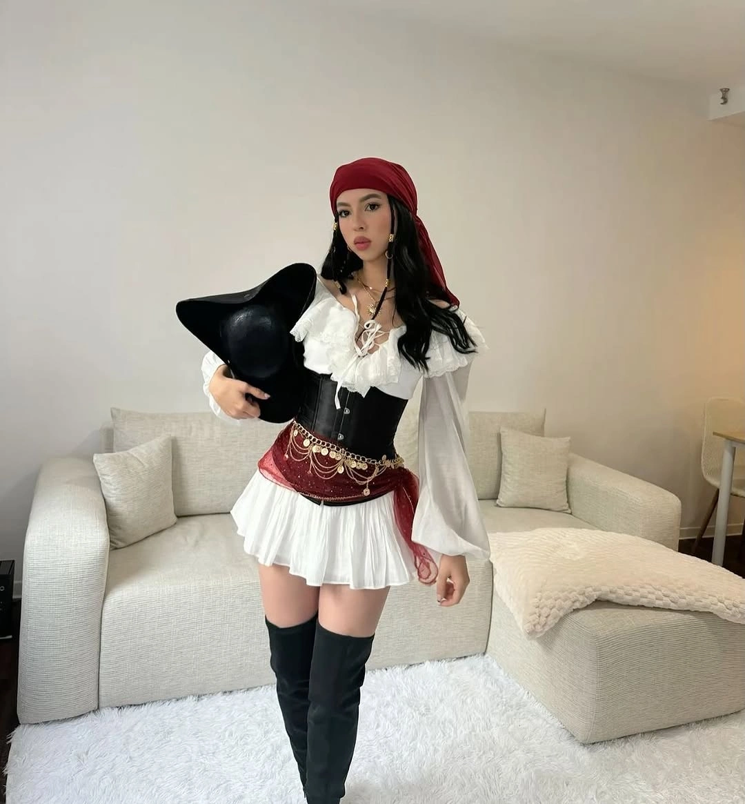 white outfit with short ruffled dress with cinched-looking waist and tall boots