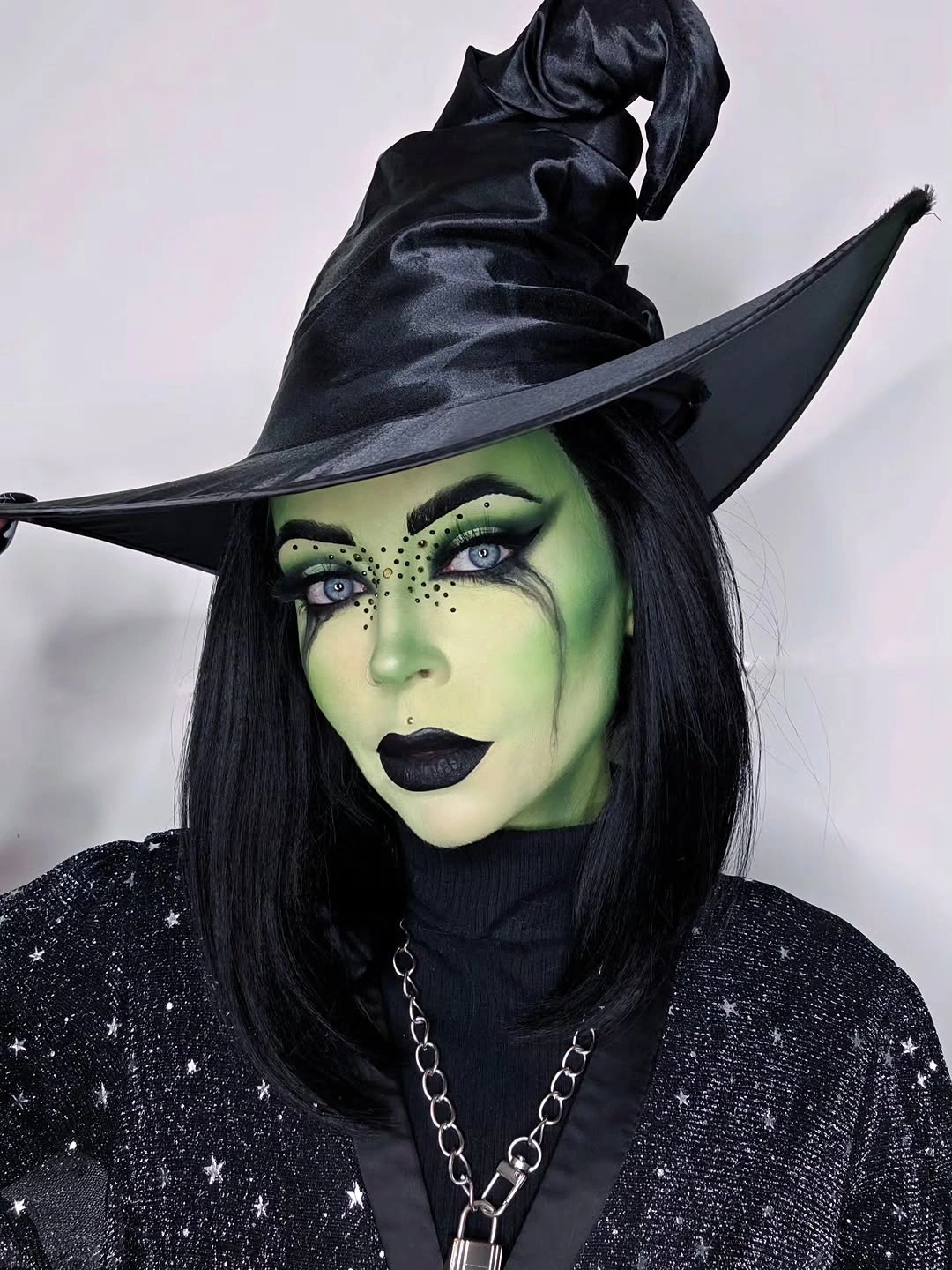 black outfit with close-up head-and-shoulders shape with oversized pointed hat