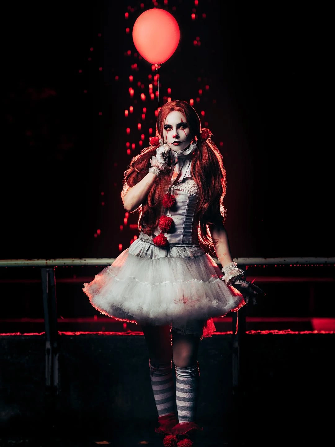 white outfit with fitted top, short rounded skirt, striped knee socks, and red hair