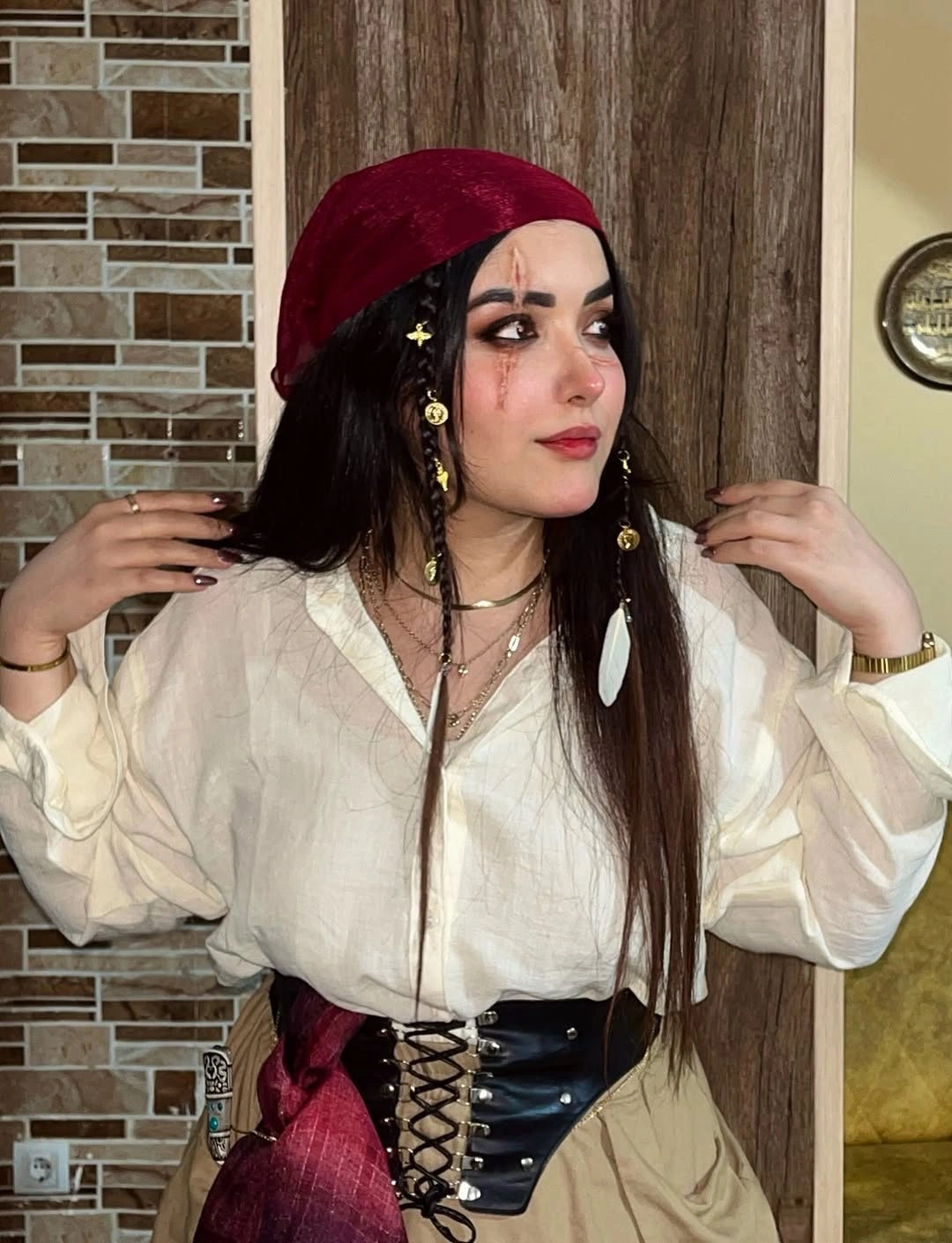 white outfit with voluminous blouse cinched by a dark waist piece with long hair framing the body