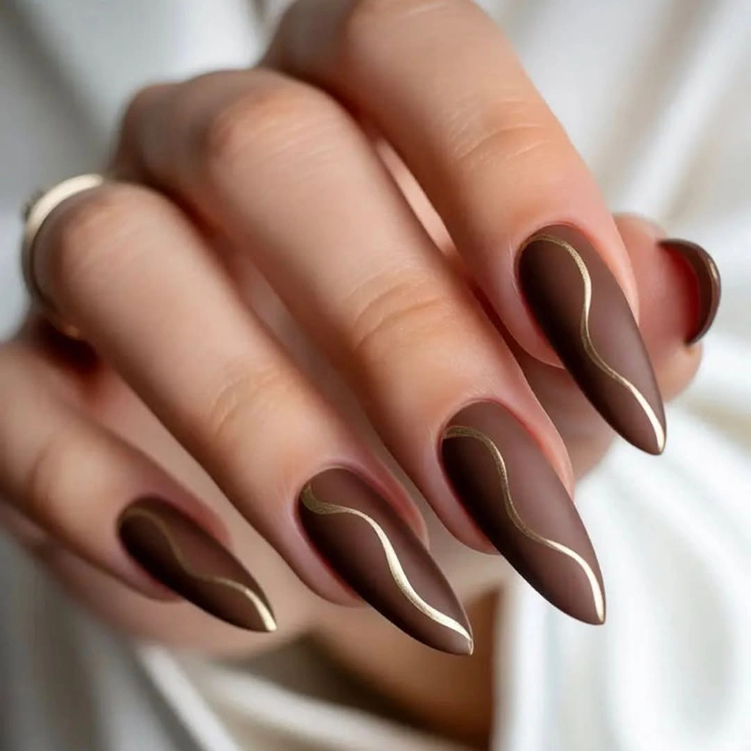 long deep brown almond nails with fine gold lines