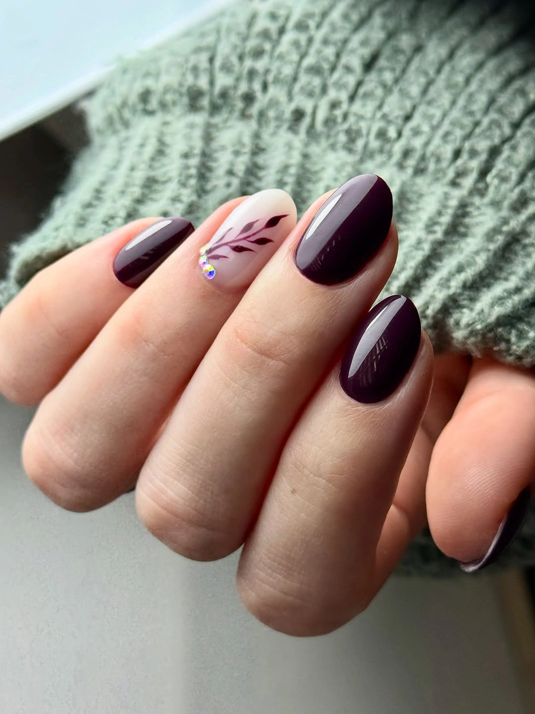short rounded plum nails with one soft floral accent