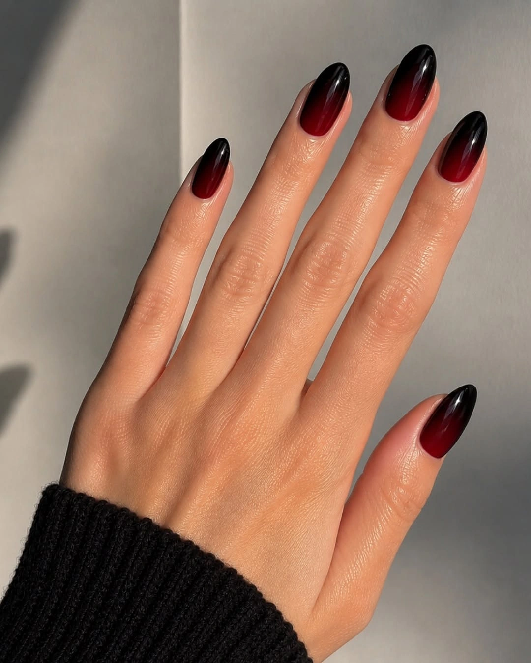 long almond nails with glossy black to red ombre
