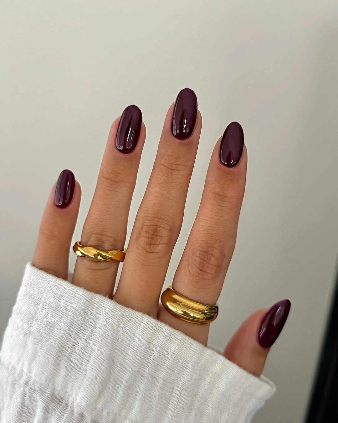 medium almond nails in a glossy deep plum shade