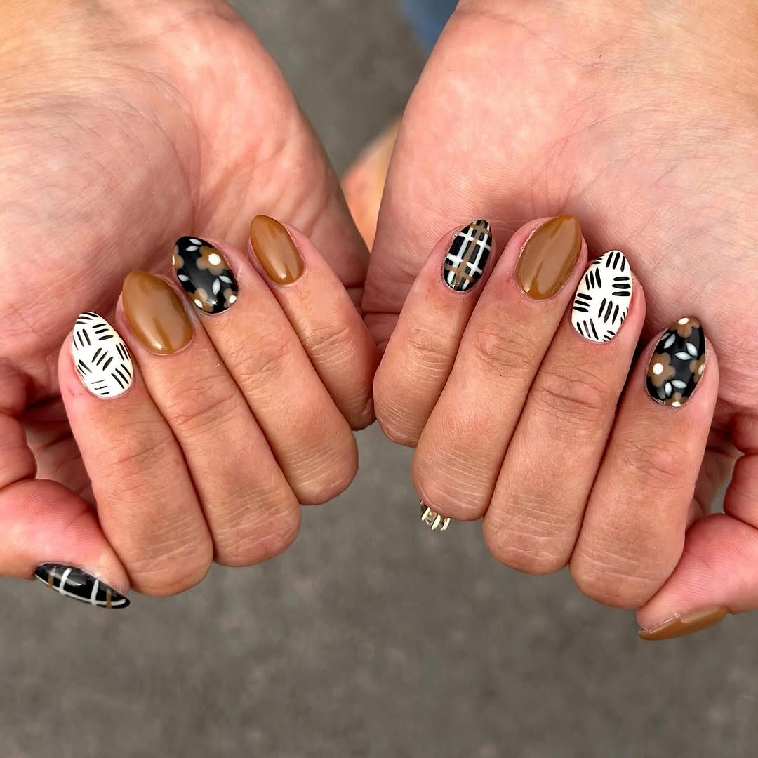 short rounded black white and tan graphic nails