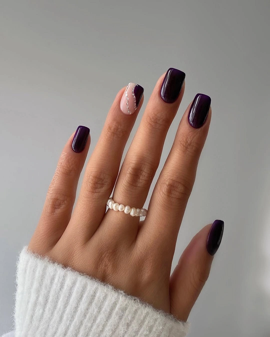 medium almond nails in a glossy solid plum shade