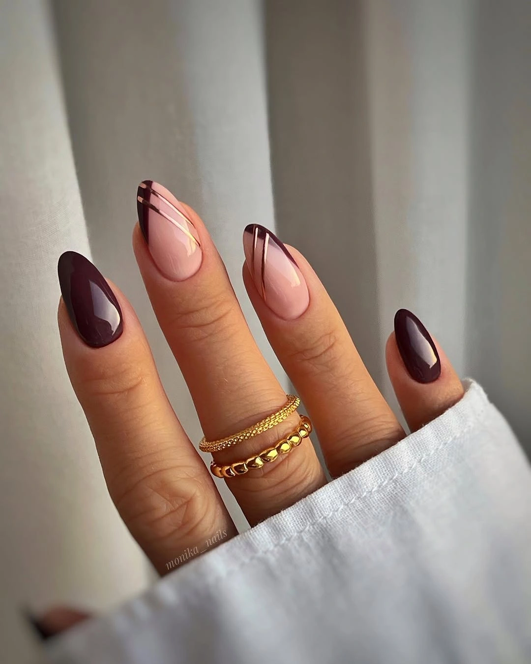 long almond nails with burgundy curves and sheer centers