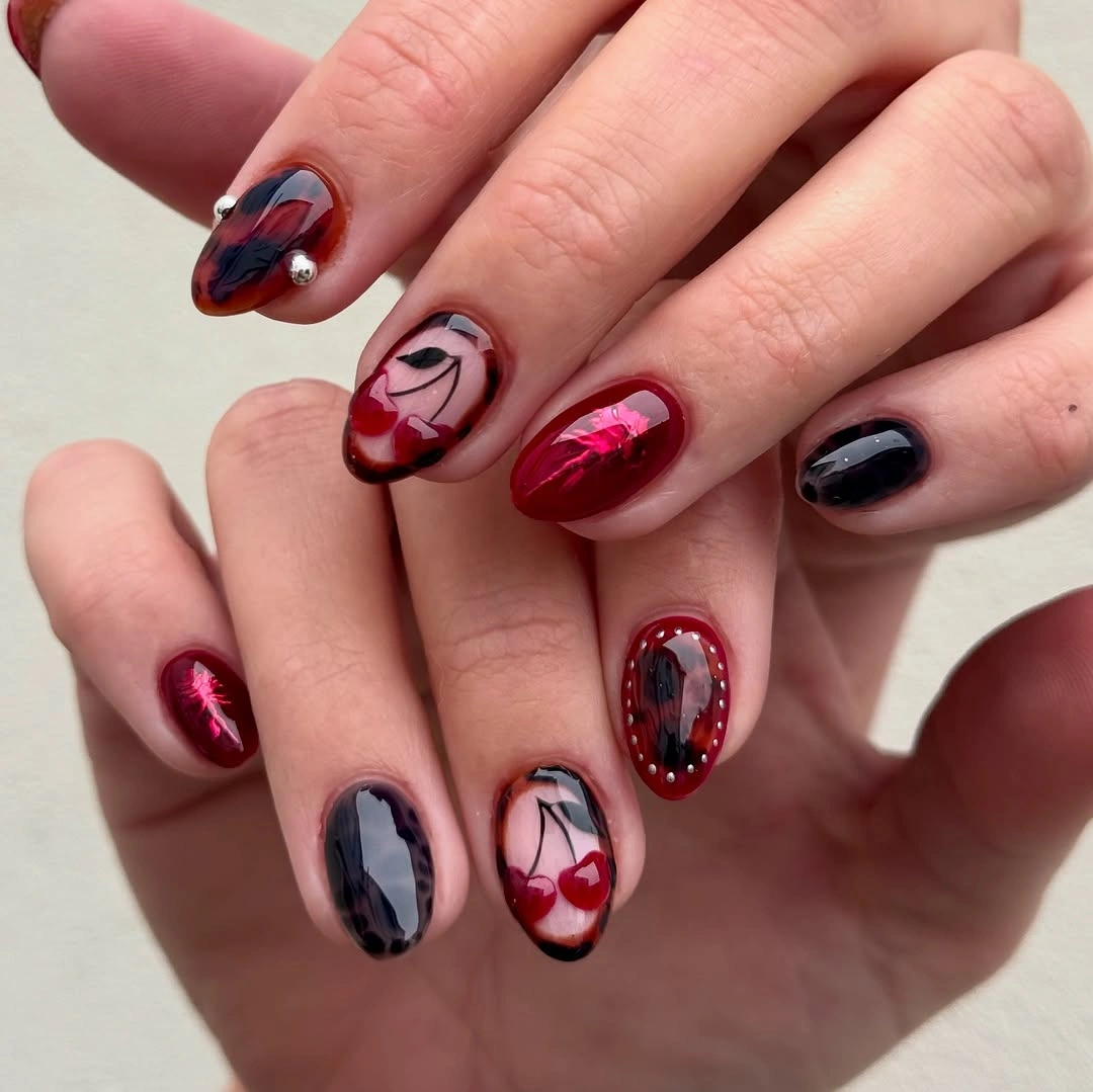 Short burgundy and black nails with a blush swirl accent