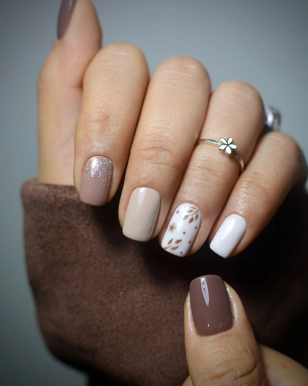 Short taupe chocolate nails with a white leaf accent