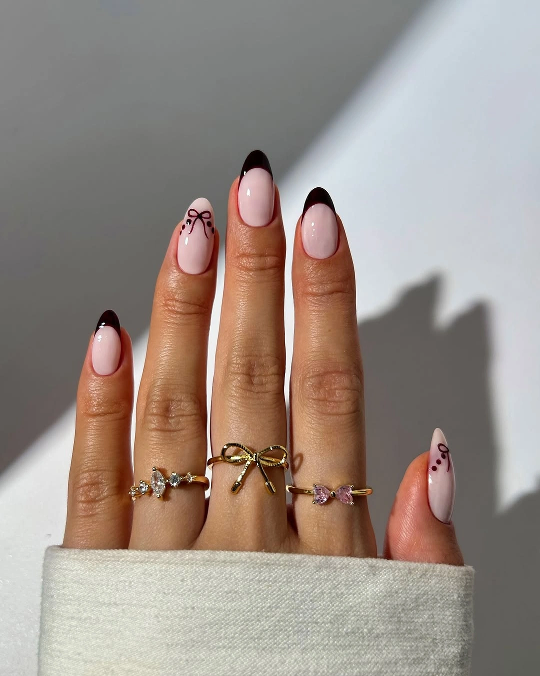 Milky pink almond nails with narrow dark tips