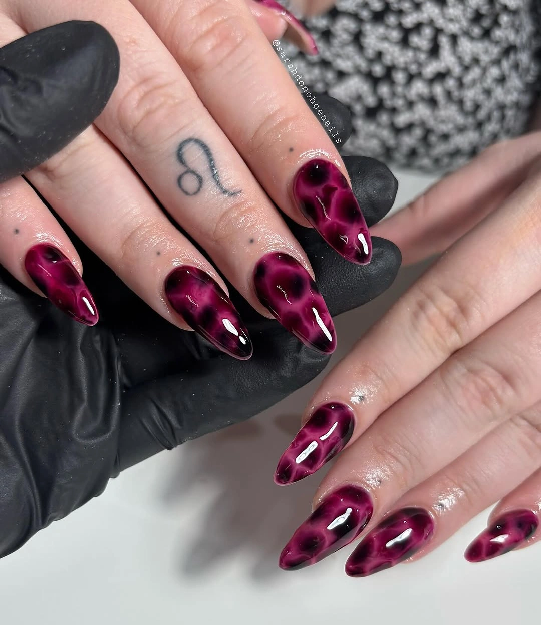 Deep magenta stiletto nails with dark shine