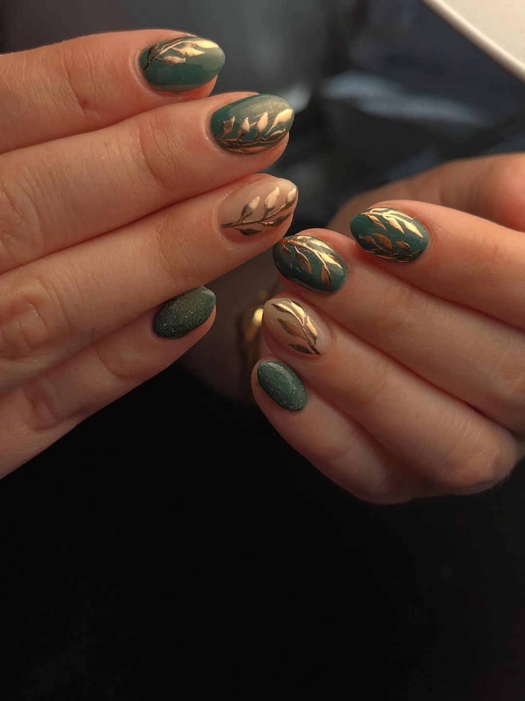 Dark green nails with gold leaf accents