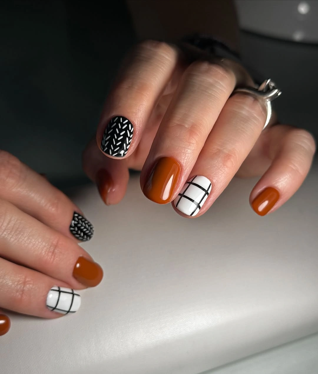 Orange and black nails with grid accent